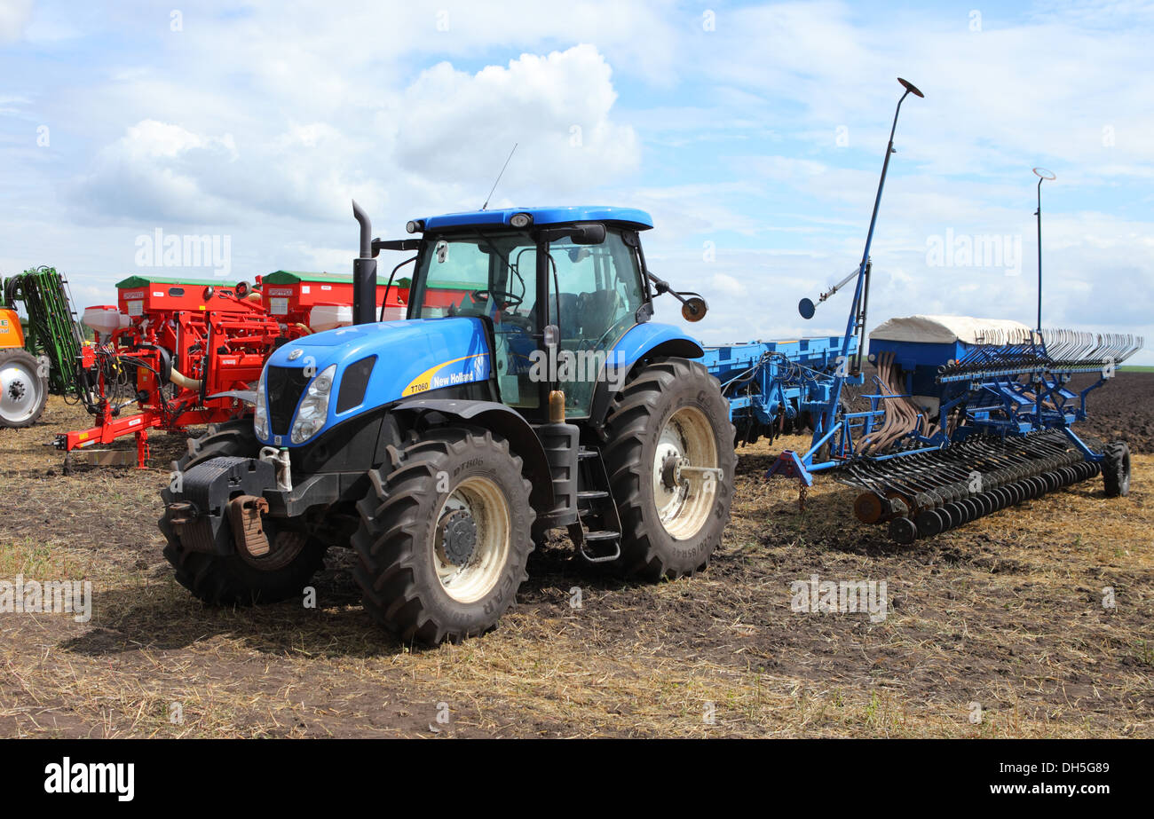 Les tracteurs New Holland bleu avec des machines agricoles Banque D'Images