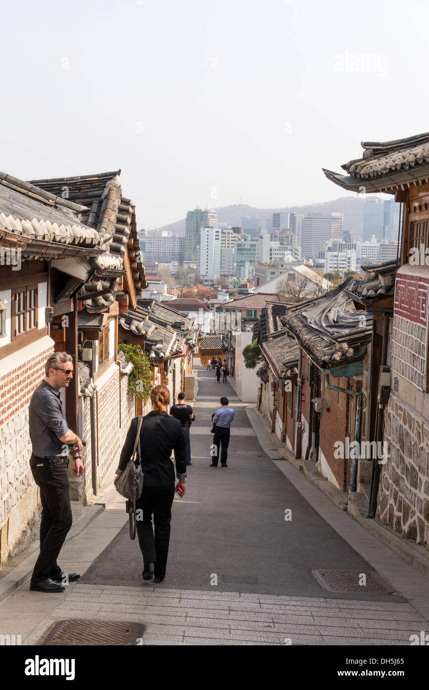 La juxtaposition de l'architecture. Vieilles maisons Coréennes traditionnelles dans le village de Bukchon Hanok et bâtiments modernes à l'arrière-plan. Banque D'Images