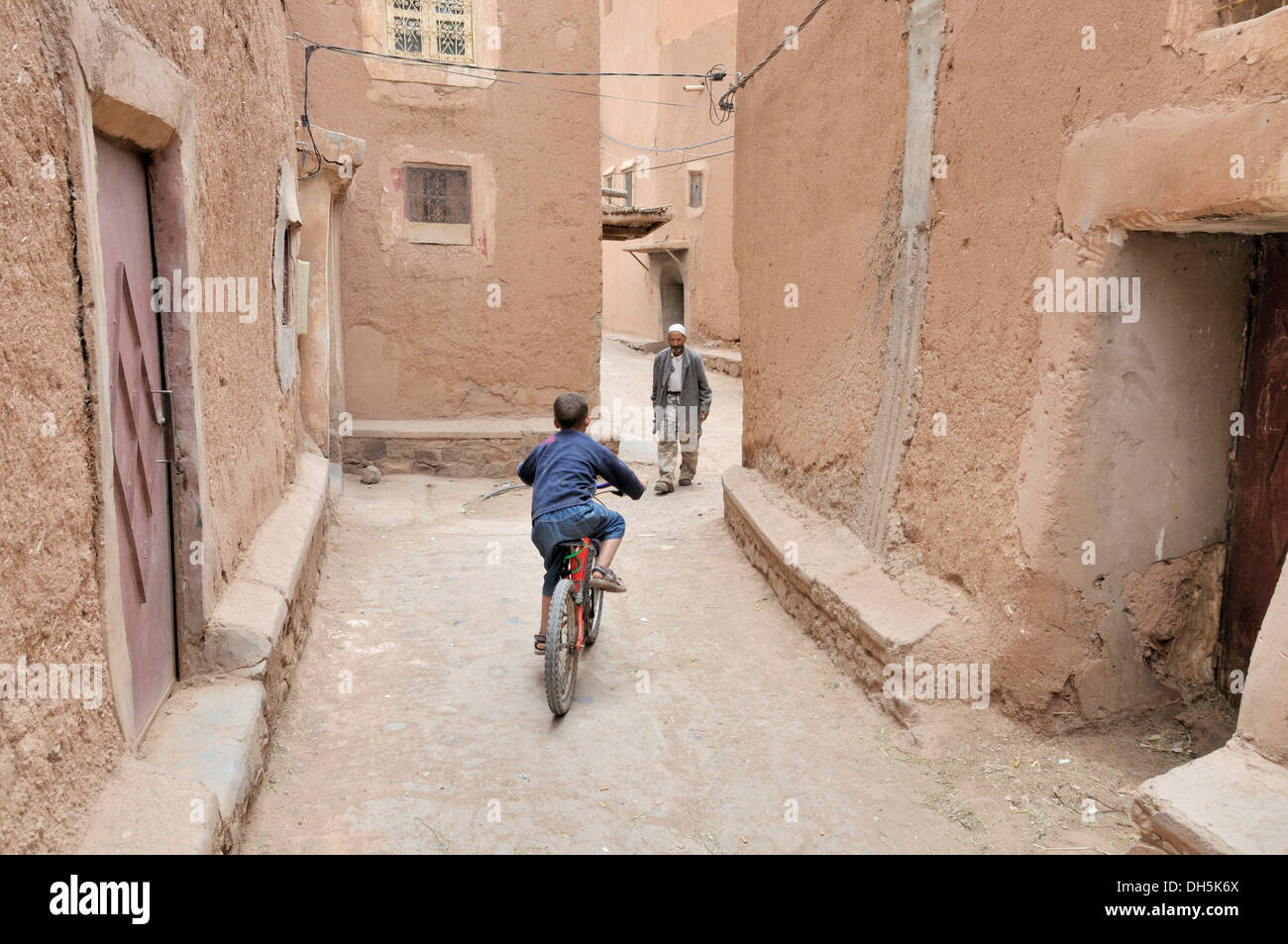 Garçon avec vélo et un vieil homme, l'architecture de pisé de terre dans la vieille ville ou Médina, Ouarzazate, Maroc, Afrique Banque D'Images