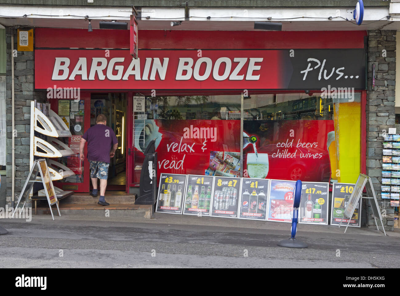 Homme entrant Bargain Booze et hors licence boutique, Bowness Banque D'Images