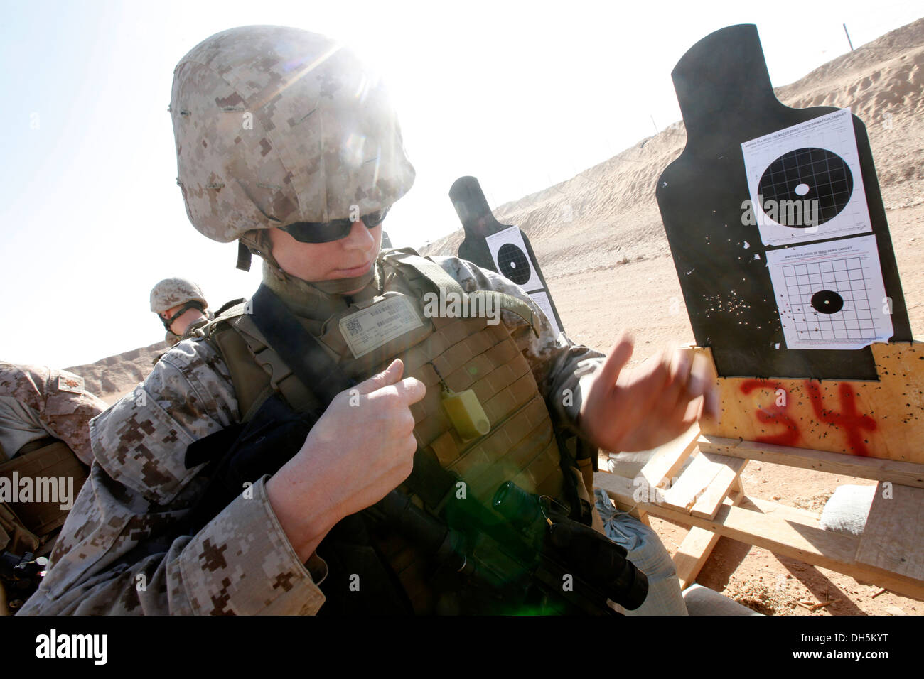 La Marine américaine Hospitalman Lindsay L. Robinson, un siège, 2e avec corpsman Marine Aircraft Wing (avant), fait des ajustements à son fusil M4 au cours d'une bataille Vue zéro (BZO) vont au Camp Sapadalure, province de Helmand, Afghanistan, le 25 octobre 2013 Banque D'Images