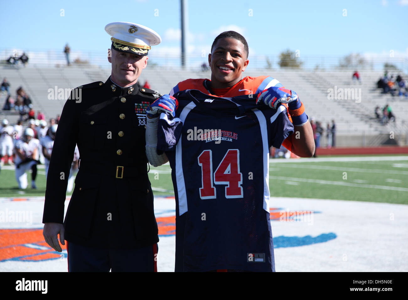 Le major Gregory P. Gordon, commandant du poste de recrutement St Louis, présente une Semper Fidelis All-American Bowl jersey à l'école secondaire senior Kyron Watson pendant un match de football à St Louis, Illinois, le 19 octobre 2013. Watson a été sélectionné pour par Banque D'Images