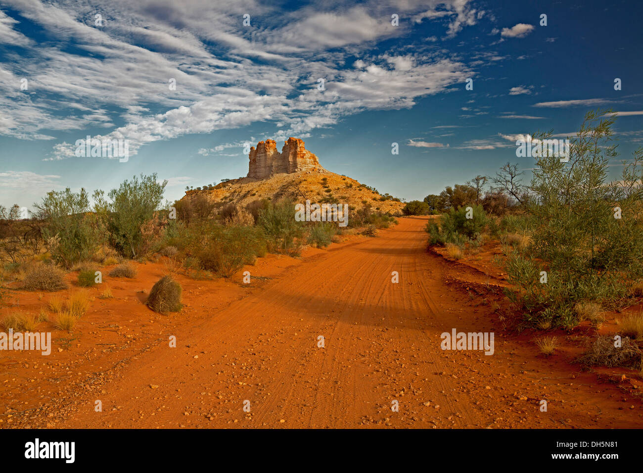 Paysage de l'Outback avec red road crossing plaines à Castle Rock, unique caractéristique géologique dans le Territoire du Nord Australie Banque D'Images