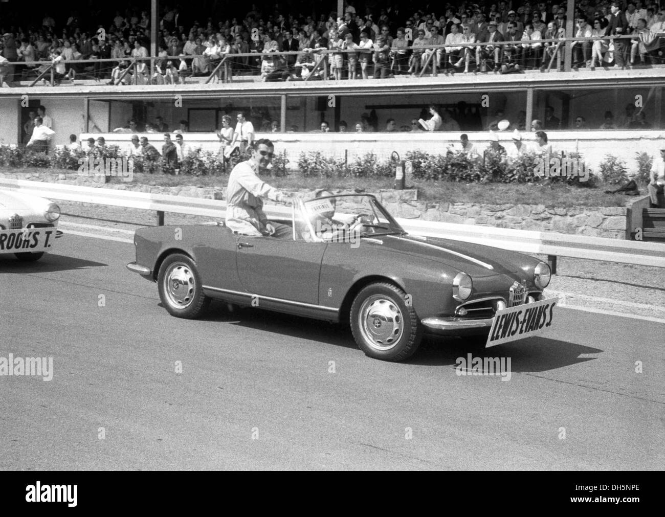 Stuart Lewis-Evans assis sur le dos d'une Alfa Romeo Giulietta Spider dans la parade à Spa Francorchamps, Belgique 1958. Banque D'Images