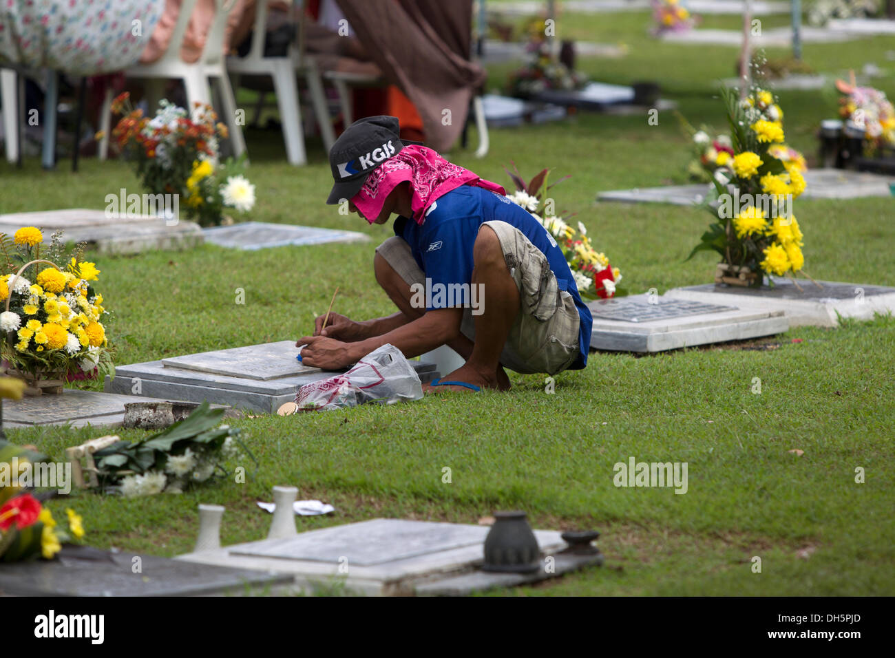 La ville de Cebu, aux Philippines. 1er novembre 2013,Cebu Memorial Park, Cebu City aux Philippines. Toussaint et un temps pour les familles catholiques des Philippines à se souvenir et rendre hommage à leurs êtres chers décédés. Ici un homme restaure la peinture sur une pierre tombale. Des parents se réuniront par la tombe en souvenir,placer des fleurs et des bougies d'éclairage. Credit : gallerie2/Alamy Live News Banque D'Images