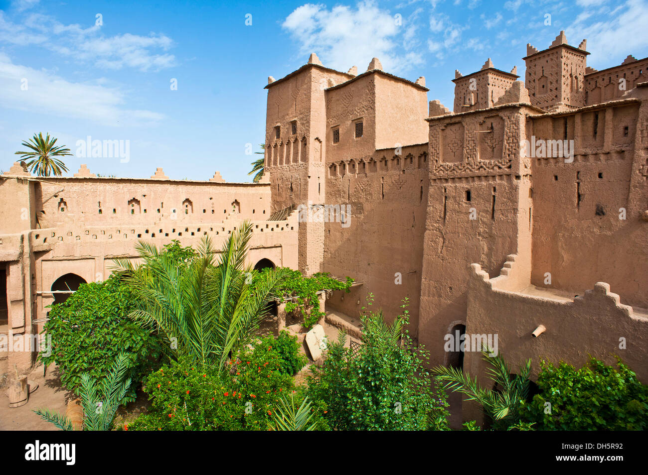 Les tours et murs avec des décorations ornementales et cour intérieure avec des arbres d'une Kasbah, forteresse de brique de boue du peuple Berbère Banque D'Images