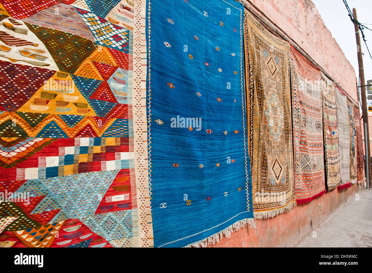 Des tapis avec des symboles arabes et berbères et les schémas, suspendu à une façade à vendre, Marrakech, Maroc, Afrique Banque D'Images
