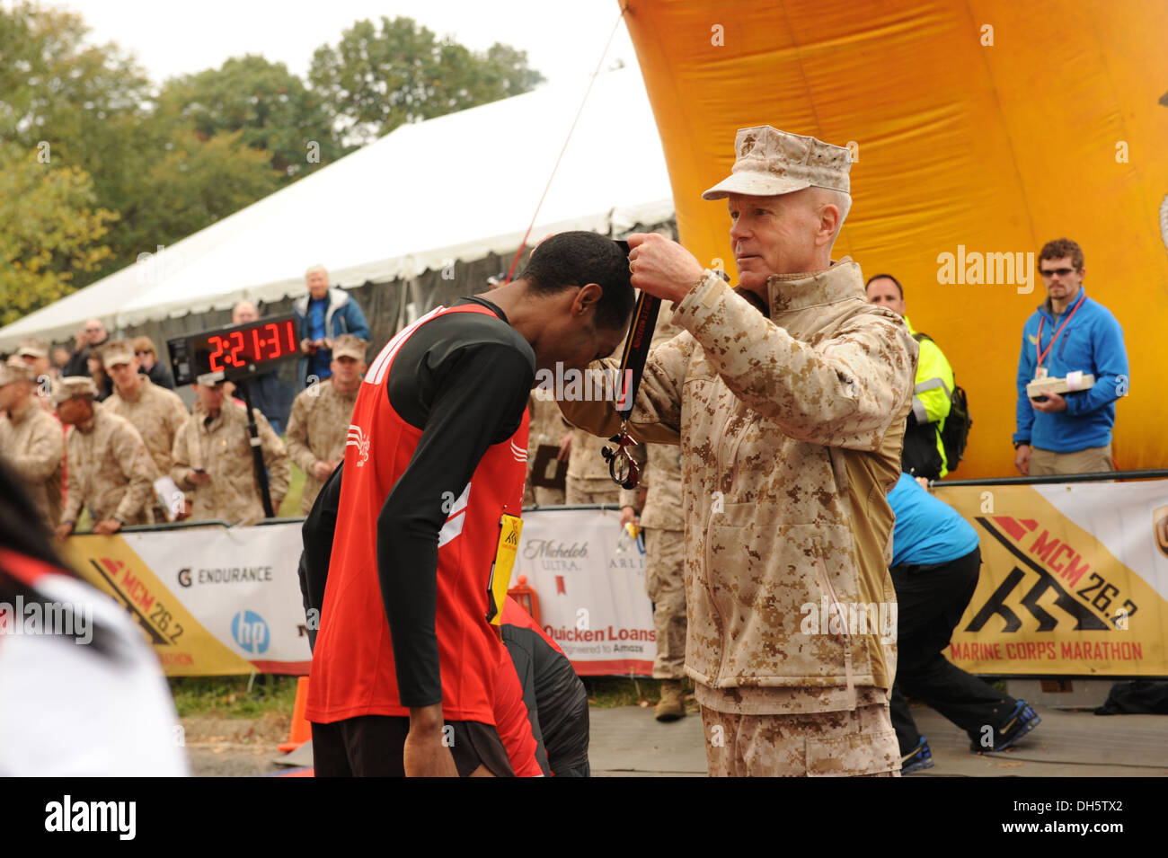 Commandant du Corps des Marines américain James F. Amos remporte le premier marathon lieu Bedada Girma module de finition de l'Éthiopie avec sa médaille à l'arrivée de la 38e conférence annuelle de Marine Corps Marathon, Washington, D.C., Octobre 27, 2013. Bedada terminé le marathon en deux heures Banque D'Images