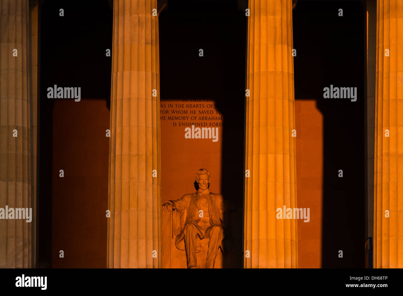 Lincoln Memorial Statue Equinox Sunrise Washington DC // WASHINGTON DC — la statue de 19 mètres du Lincoln Memorial est directement exposée à la lumière du soleil lors d'un lever de soleil d'équinoxe. L'alignement précis est-ouest du mémorial permet à la lumière du soleil d'éclairer la figure assise de Daniel Chester French seulement près des équinoxes de printemps et d'automne. Le soleil levant crée des effets de lumière dramatiques dans la chambre commémorative. Banque D'Images