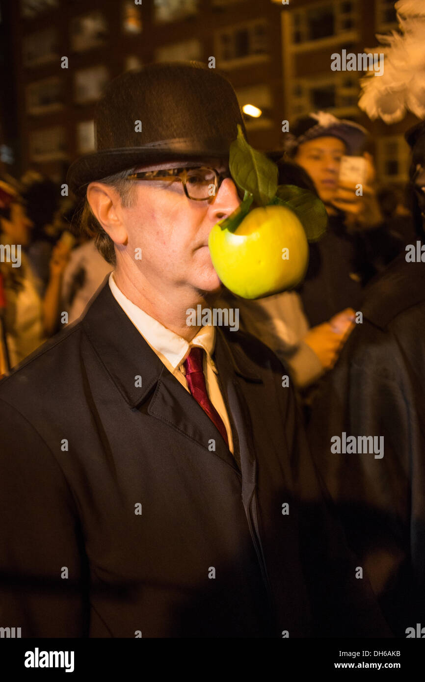 New York, NY, 31 octobre 2013. Un homme porte un chapeau melon avec une  pomme verte collée à l'avant de son visage referenceing d'un tableau de  René Magritte dans le Greenwich Village