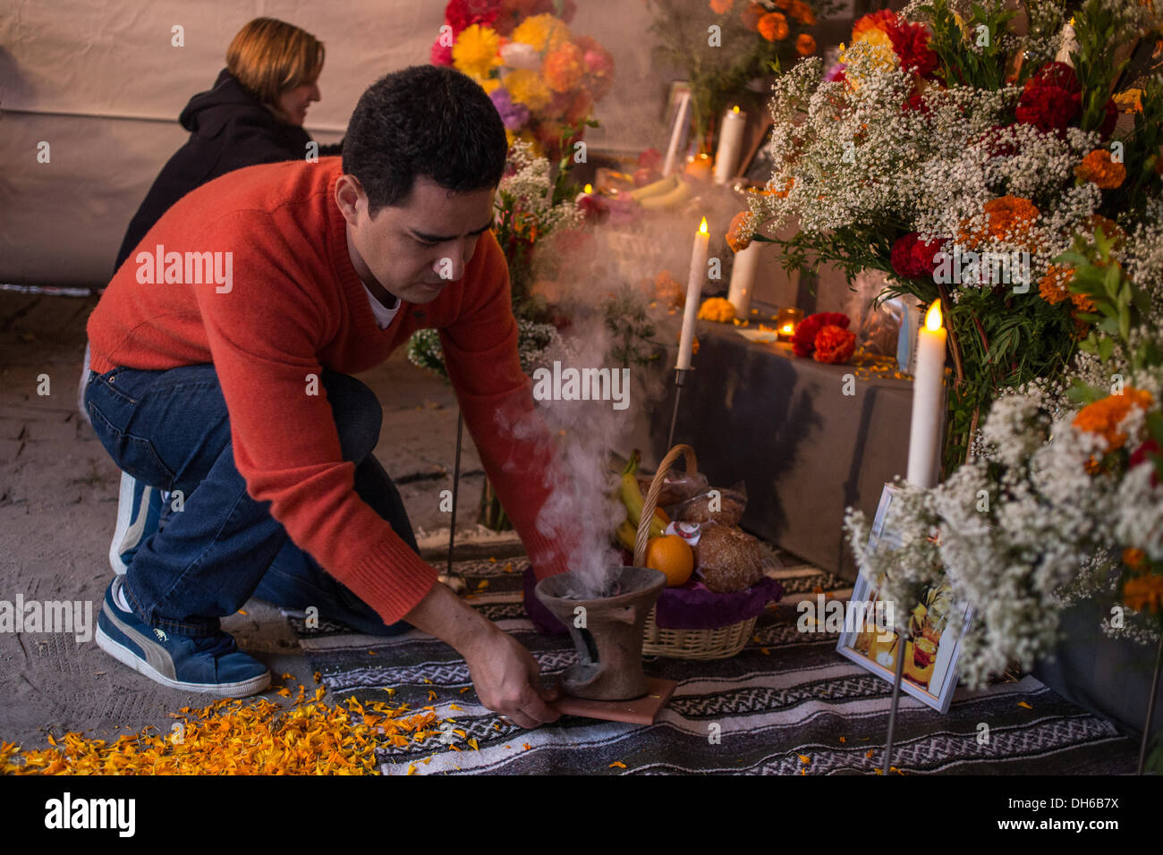 New York, NY, 31 octobre 2013. Juan Carlos Aguirre, Directeur exécutif de mano a mano, ajoute le copal à un censeur en face de l'autel du public. Sur la Fête des Morts, El Dia de los Muertos, ou le Jour des morts, les offres sont placées sur un autel à la mémoire des défunts de la famille et des amis. Credit : Ed Lefkowicz/Alamy Live News Banque D'Images