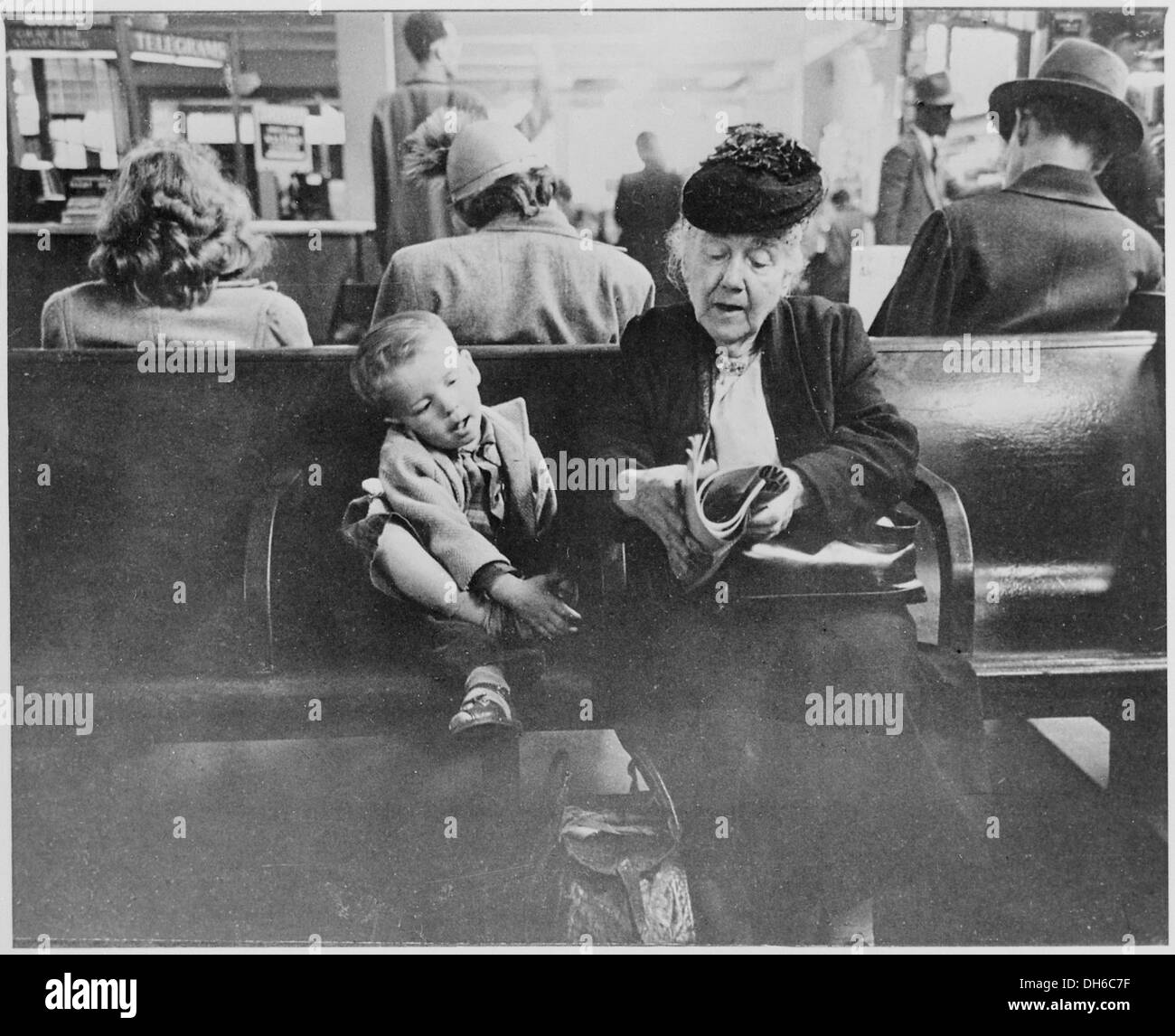 Grand-mère amusant son jeune compagnon dans la salle d'attente de la Greyhound Bus Station, New York City, 541942 07-1947 Banque D'Images