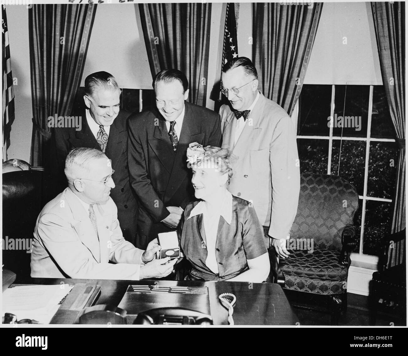 Une photographie du président Harry S. Truman dans le bureau ovale, recevant une médaille d'or commémorative du Mémorial national de la seconde Guerre mondiale. La médaille honore son leadership pendant la guerre. Banque D'Images