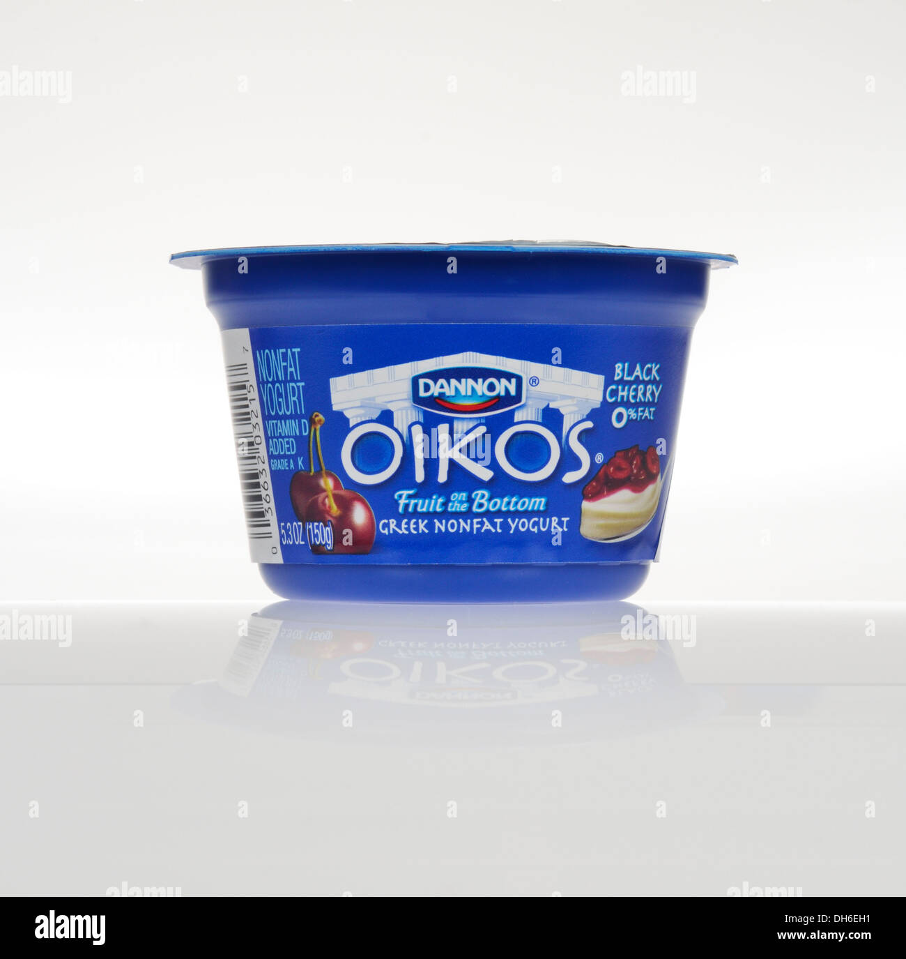 Dannon non ouvert de cerise noire Le yogourt grec oikos pot sur fond blanc, découpe. USA Banque D'Images