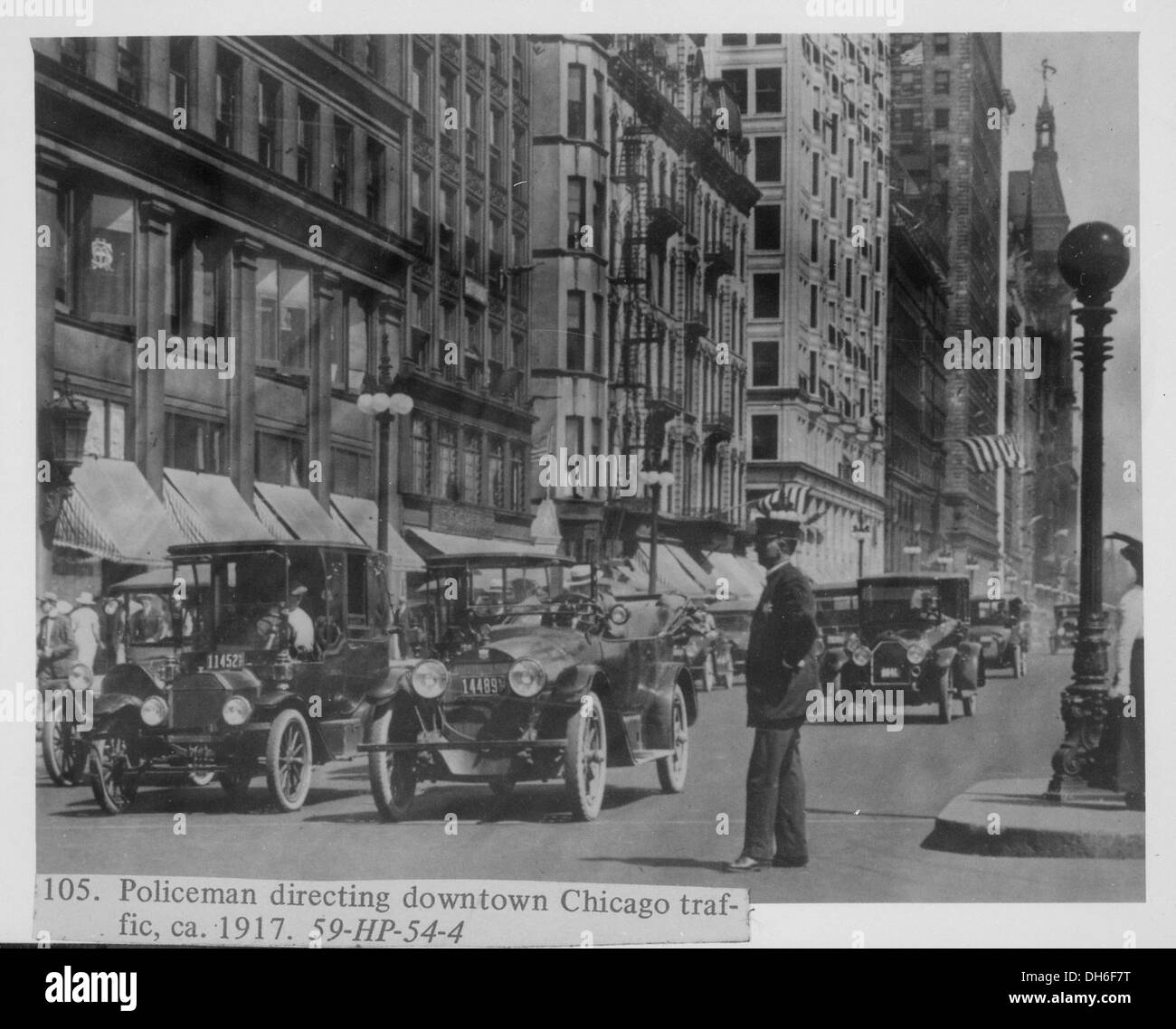 Un policier est vu diriger la circulation dans le centre-ville de Chicago vers 1917, capturant la gestion de la circulation urbaine du début du XXe siècle. Banque D'Images