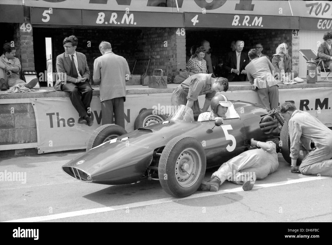 Tony Rudd et Peter Berthon, avec Dan Gurney dans sa BRM P48 dans les stands à la British GP, Silverstone, Angleterre 1960. Banque D'Images