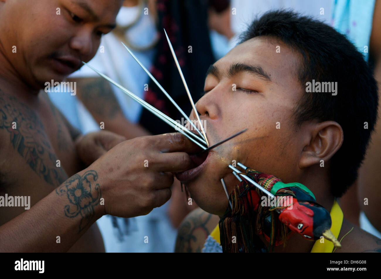 Ma-Thong (Spirit medium) se faisant percer la joue avec de longues aiguilles pendant le Festival végétarien de Phuket, Phuket Town, Thaïlande. © Kraig Lieb Banque D'Images