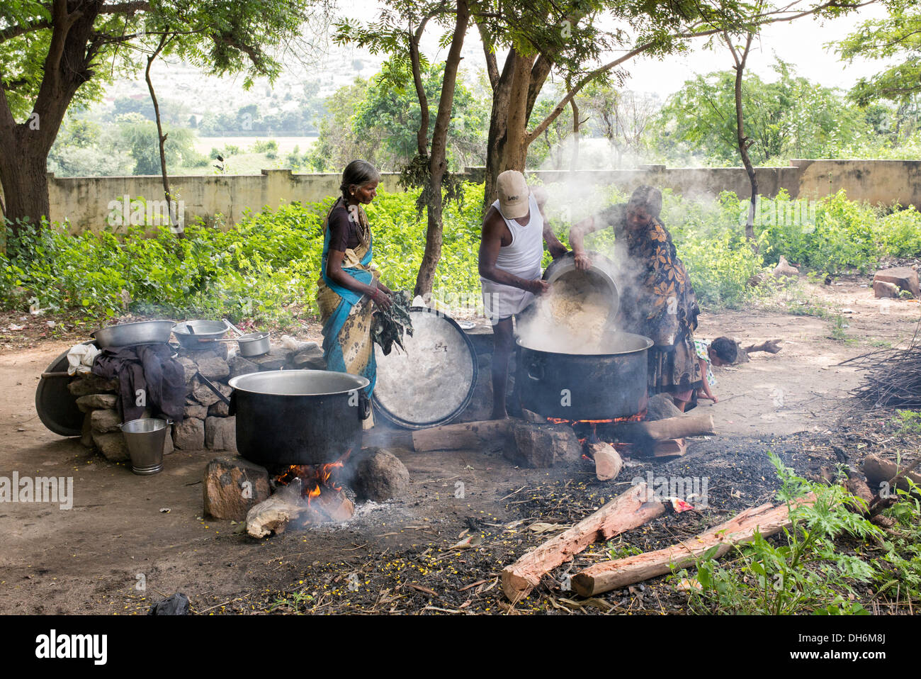 Les Indiens la cuisson des repas à l'école de feux ouverts à un village indien rural high school. L'Andhra Pradesh, Inde Banque D'Images
