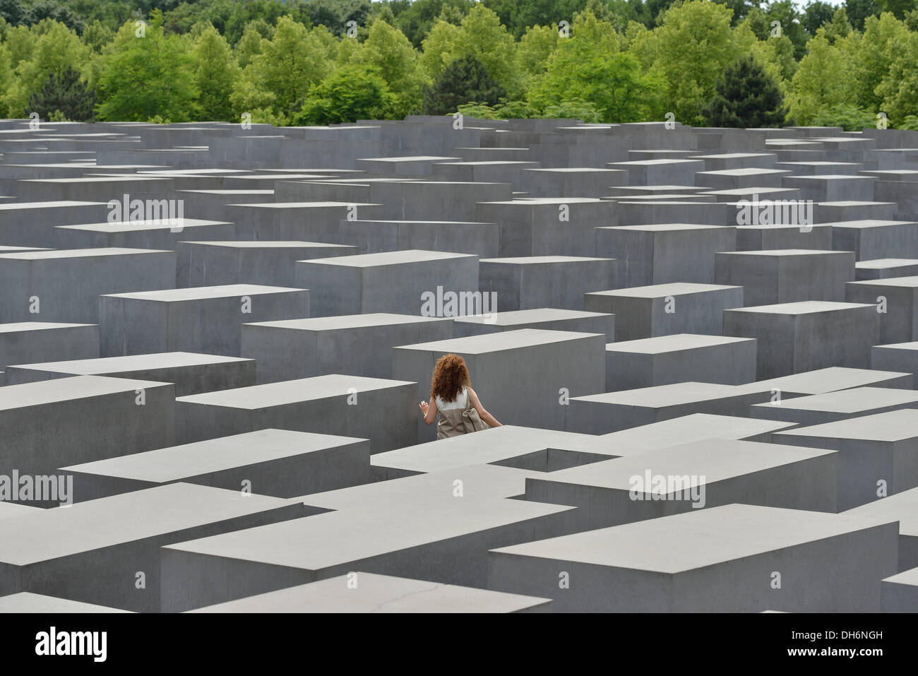 Berlin. L'Allemagne. Mémorial aux Juifs assassinés d'Europe / Holocaust Memorial, une femme seule se promène entre les stèles. Banque D'Images