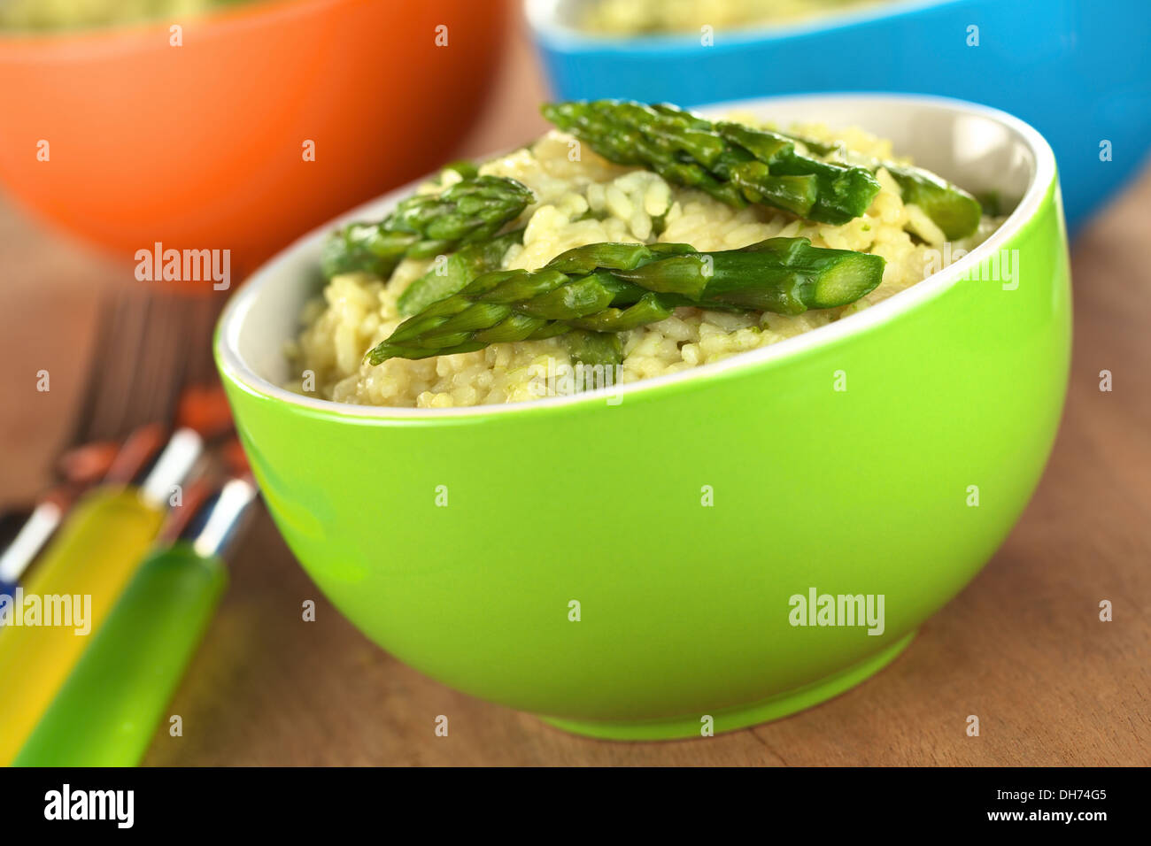 Risotto aux asperges vertes dans des bols colorés (Selective Focus, Focus sur la pointe d'asperge à l'avant) Banque D'Images