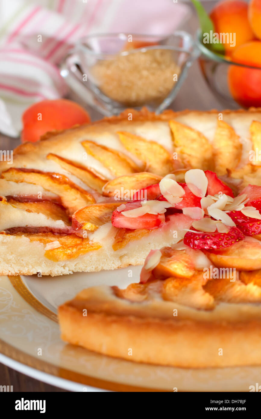 Tarte aux abricots et amandes décoré avec des fraises fraîches Banque D'Images