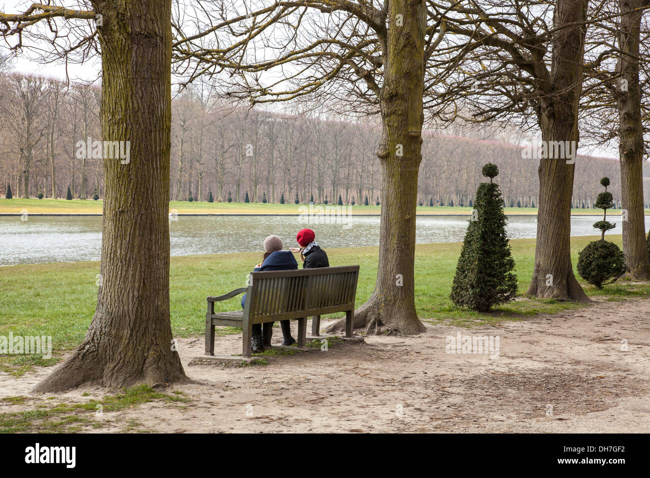 Les femmes assises sur un banc dans les jardins de Versailles, Paris, France Banque D'Images