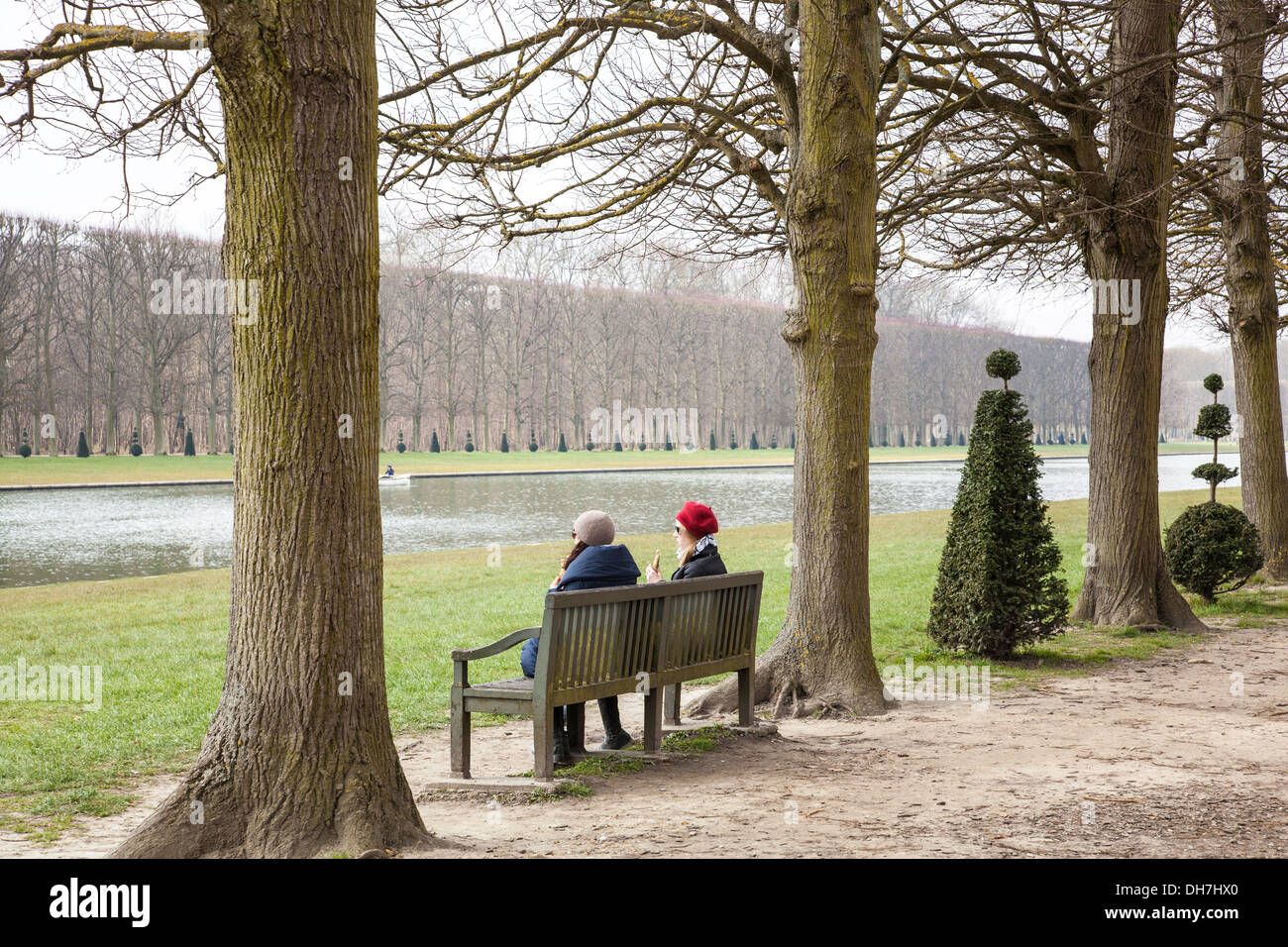 Les femmes assises sur un banc dans les jardins de Versailles, Paris, France Banque D'Images