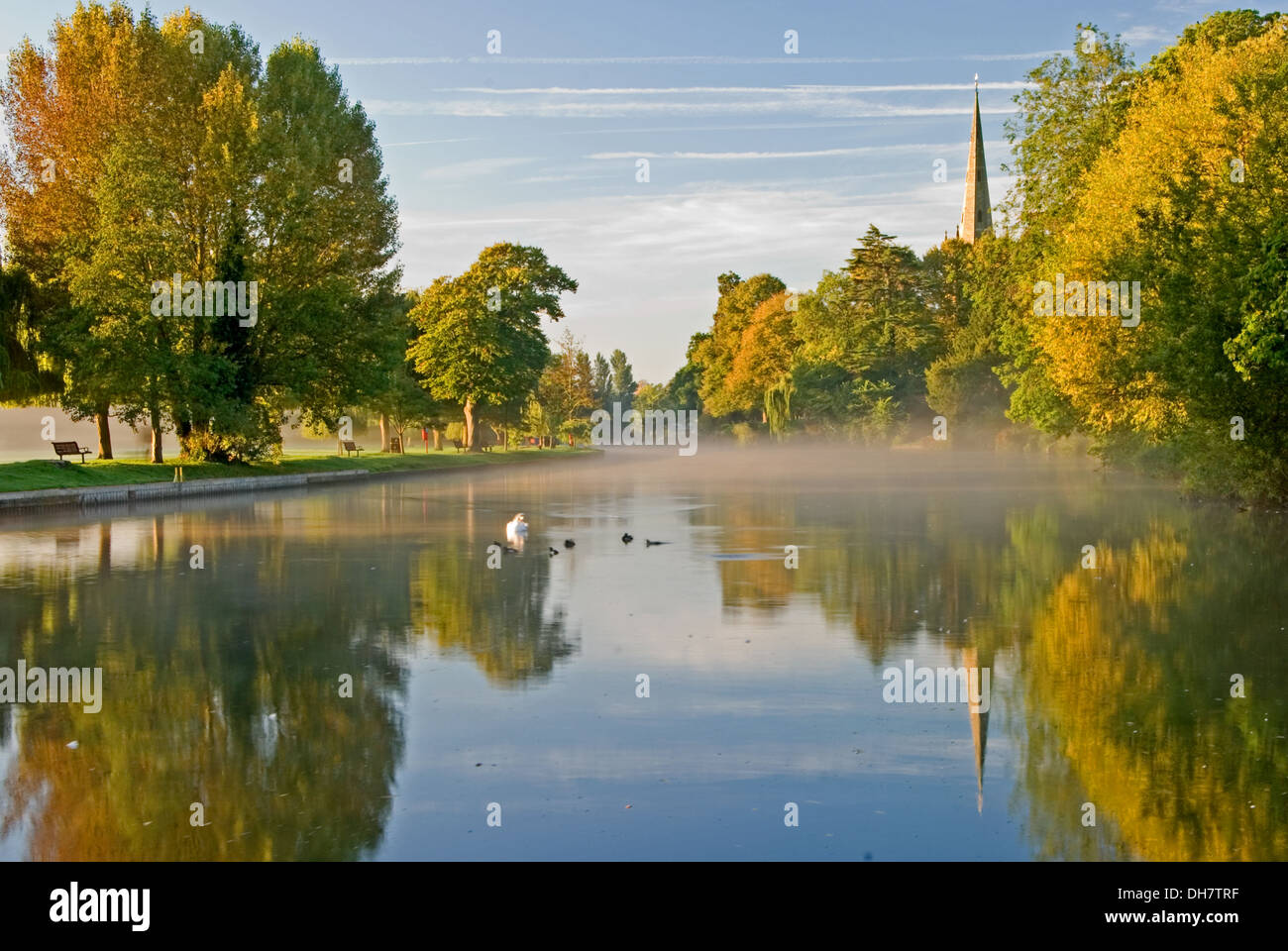 Réflexions d'automne sur la rivière Avon, avec une vue vers l'église Holy Trinity, lieu de sépulture de William Shakespeare à Stratford upon Avon. Banque D'Images