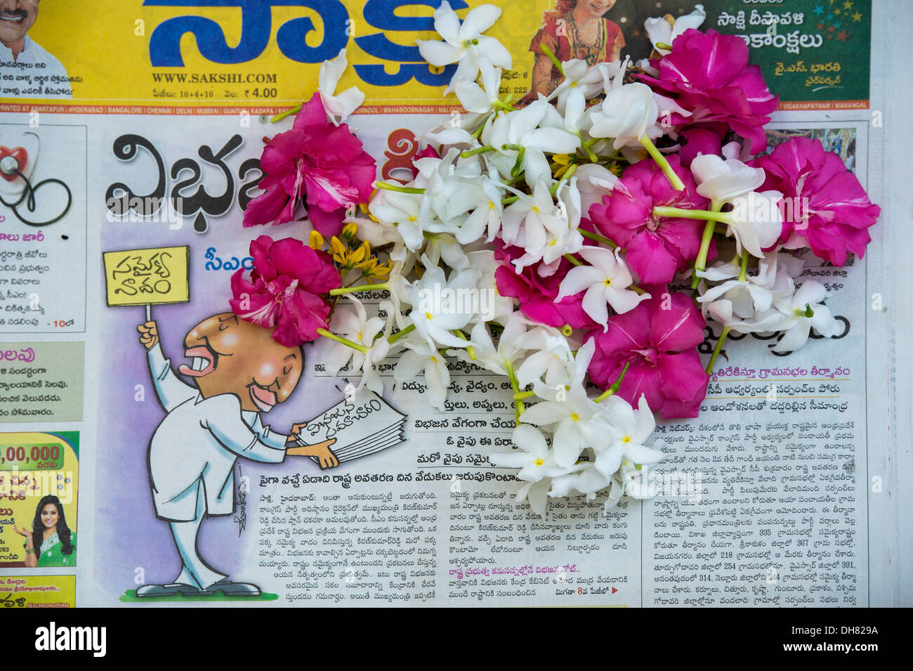 Fleurs cueillies pour offrandes religieuses sur un Indien Telegu journal. L'Inde Banque D'Images