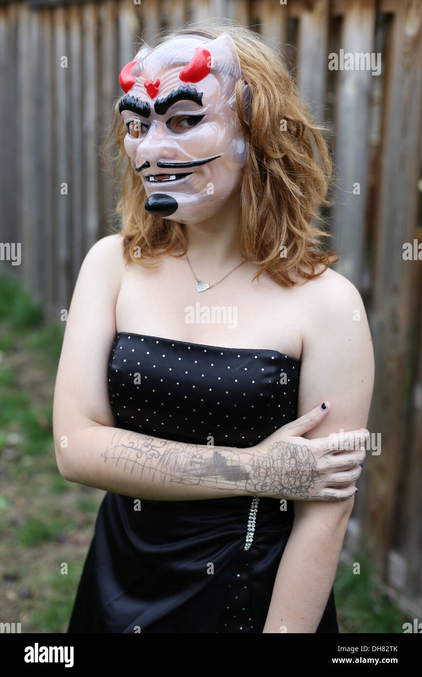 Une fille de l'adolescence portant un masque de diable. Banque D'Images
