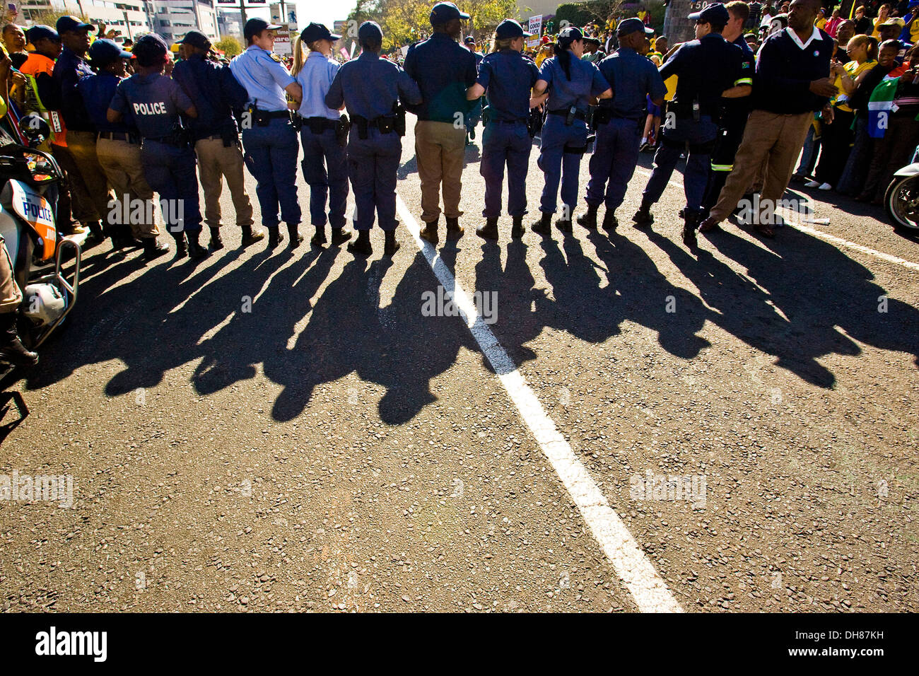 La police tente de maintenir l'ordre comme des milliers de fans de football se sont réunis dans les rues de Johannesburg pour saluer le Sud Banque D'Images