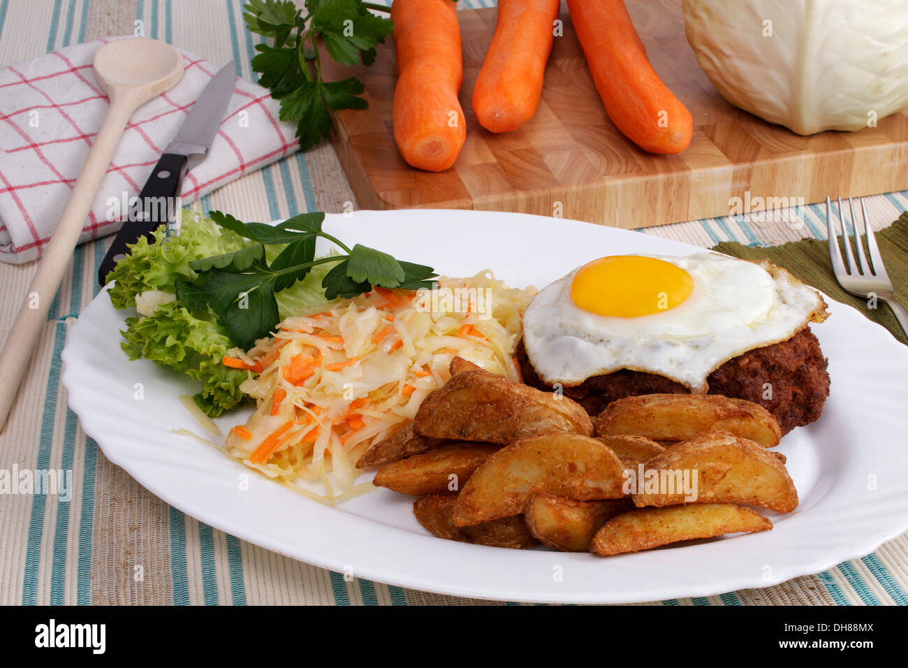 Viande agriculteurs, hamburger steak, œuf frit, pomme au four, salade de choux, carottes, chou blanc et de persil plat Banque D'Images