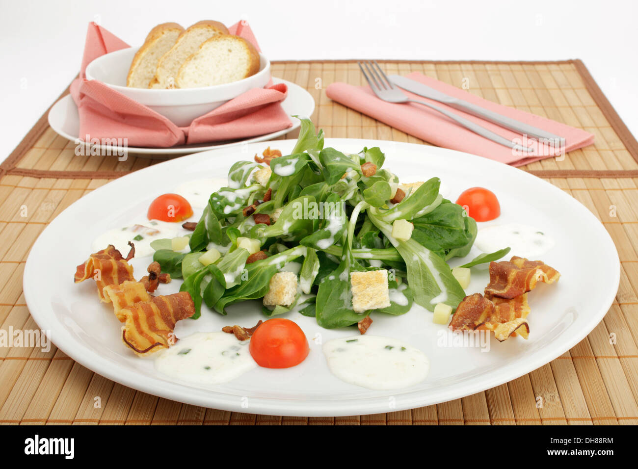 Salade de pommes de terre sur le terrain avec la vinaigrette, croûtons de pain, lard grillé et pain français Banque D'Images