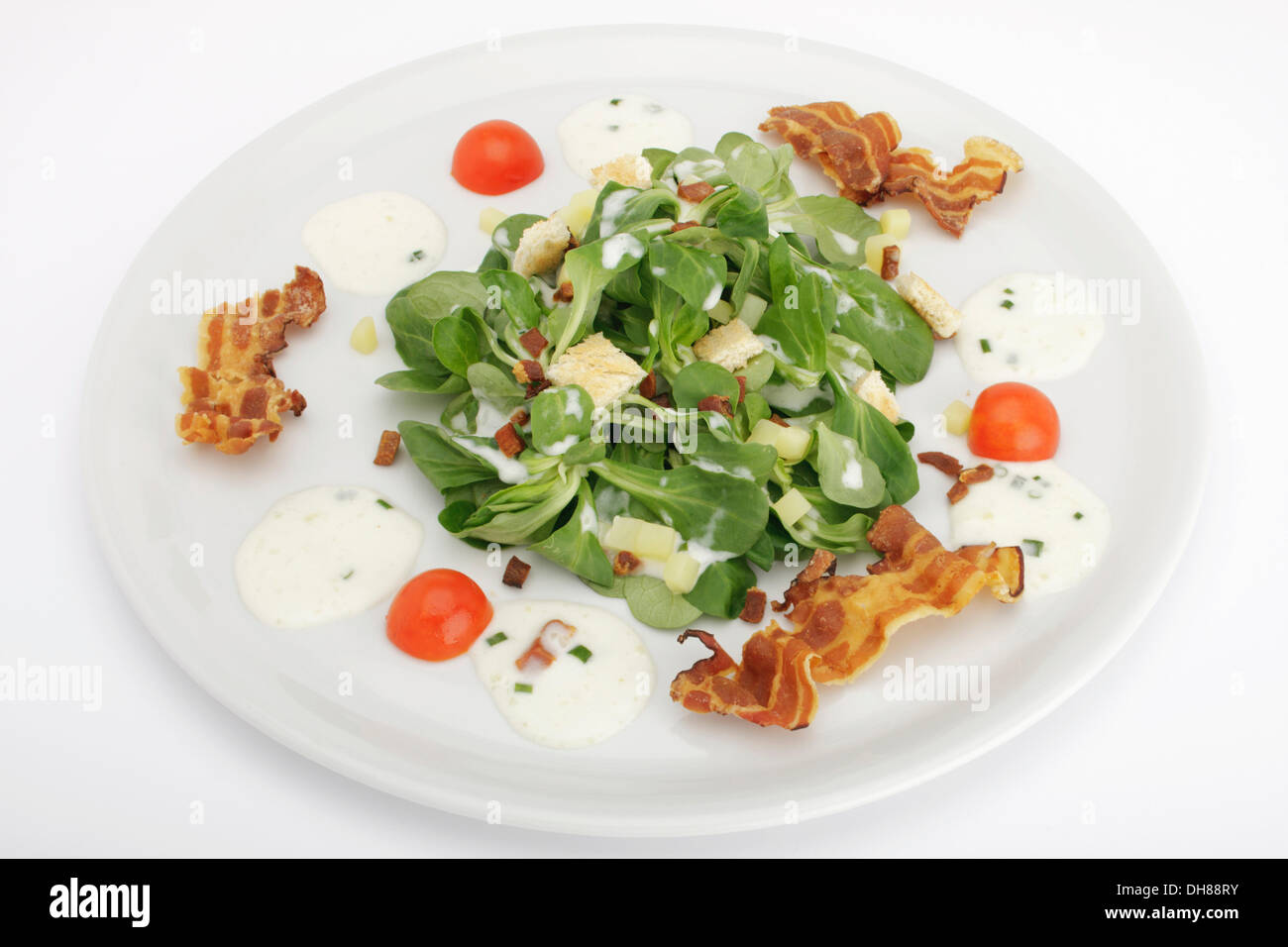 Salade de pommes de terre sur le terrain avec la vinaigrette, croûtons de pain et lard grillé Banque D'Images
