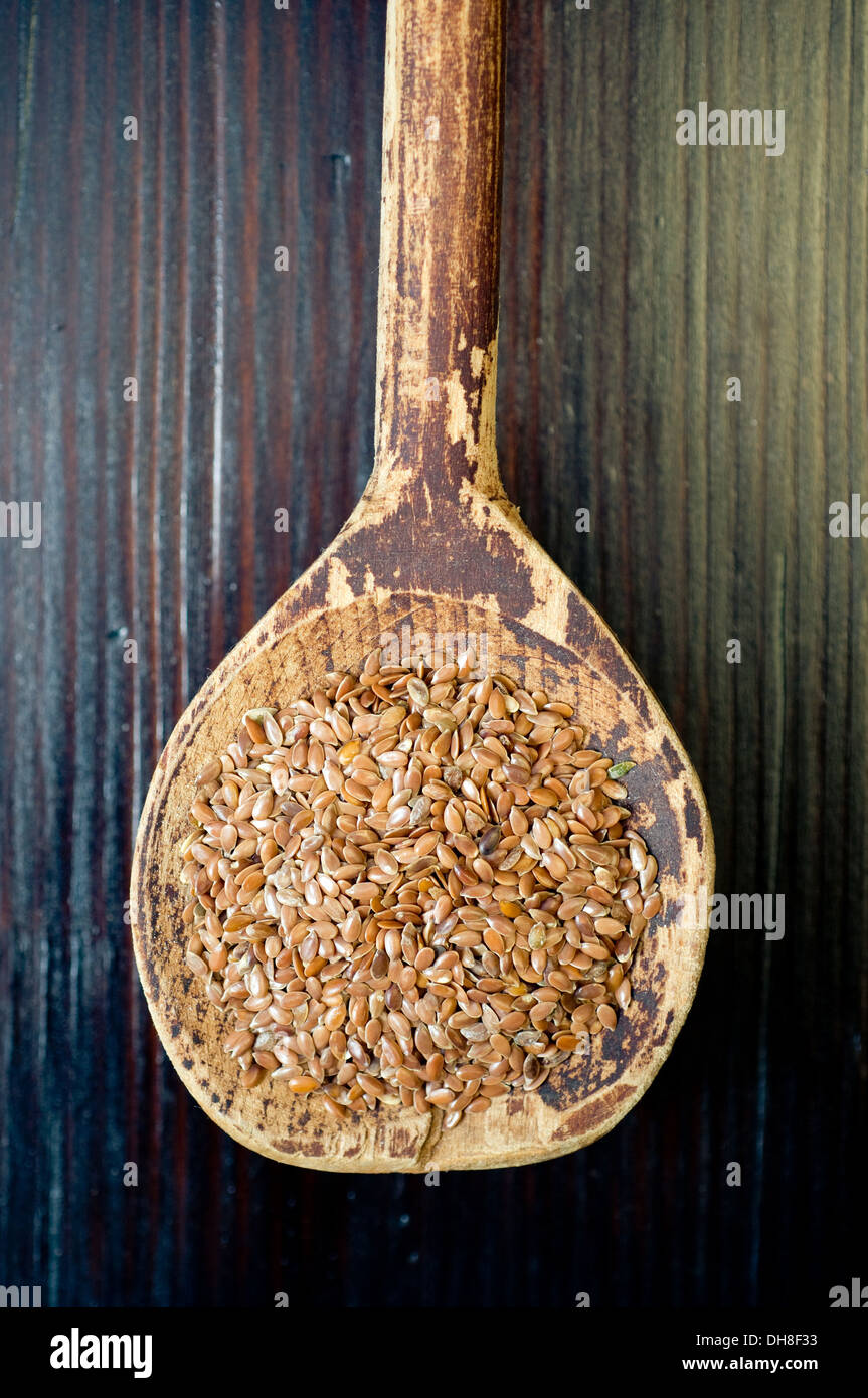 Les graines de lin sur la vieille cuillère en bois Banque D'Images