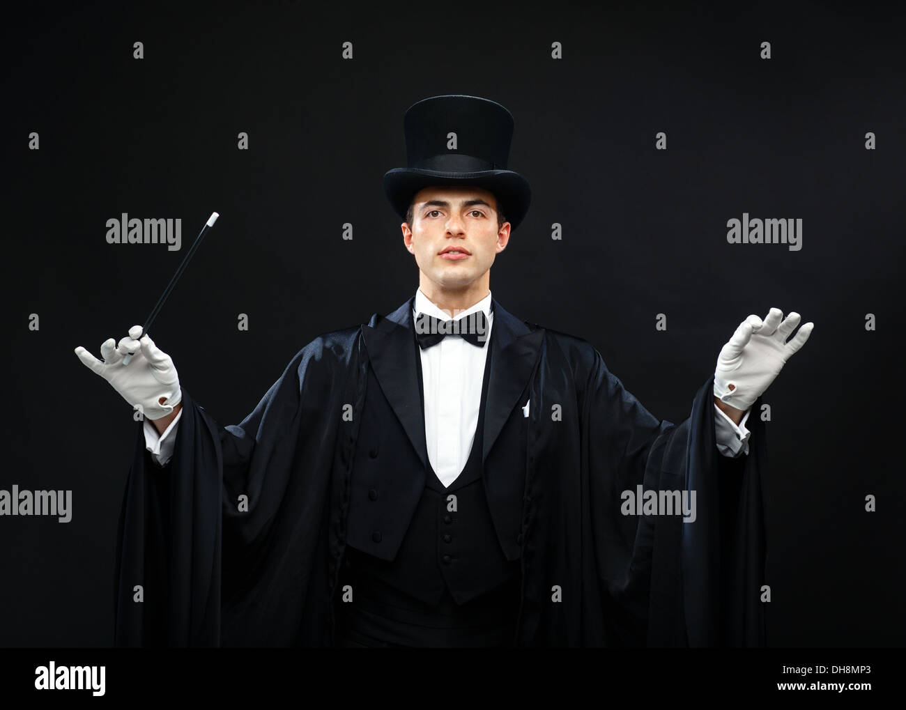 Magicien dans top hat avec Magic wand montrant trick Banque D'Images