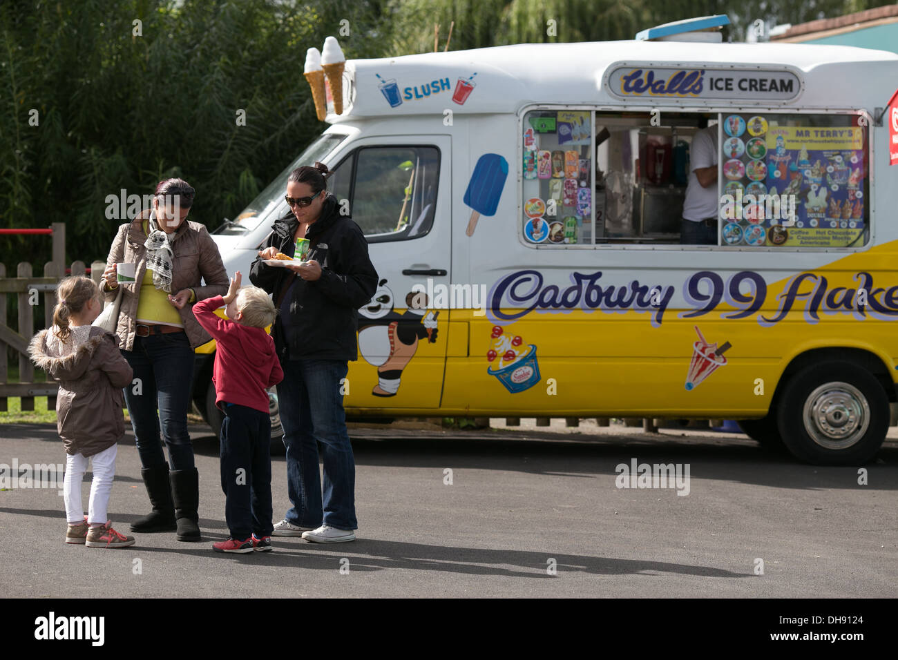 Deux femmes et deux enfants devant une glace van lors d'une fête d'été Banque D'Images