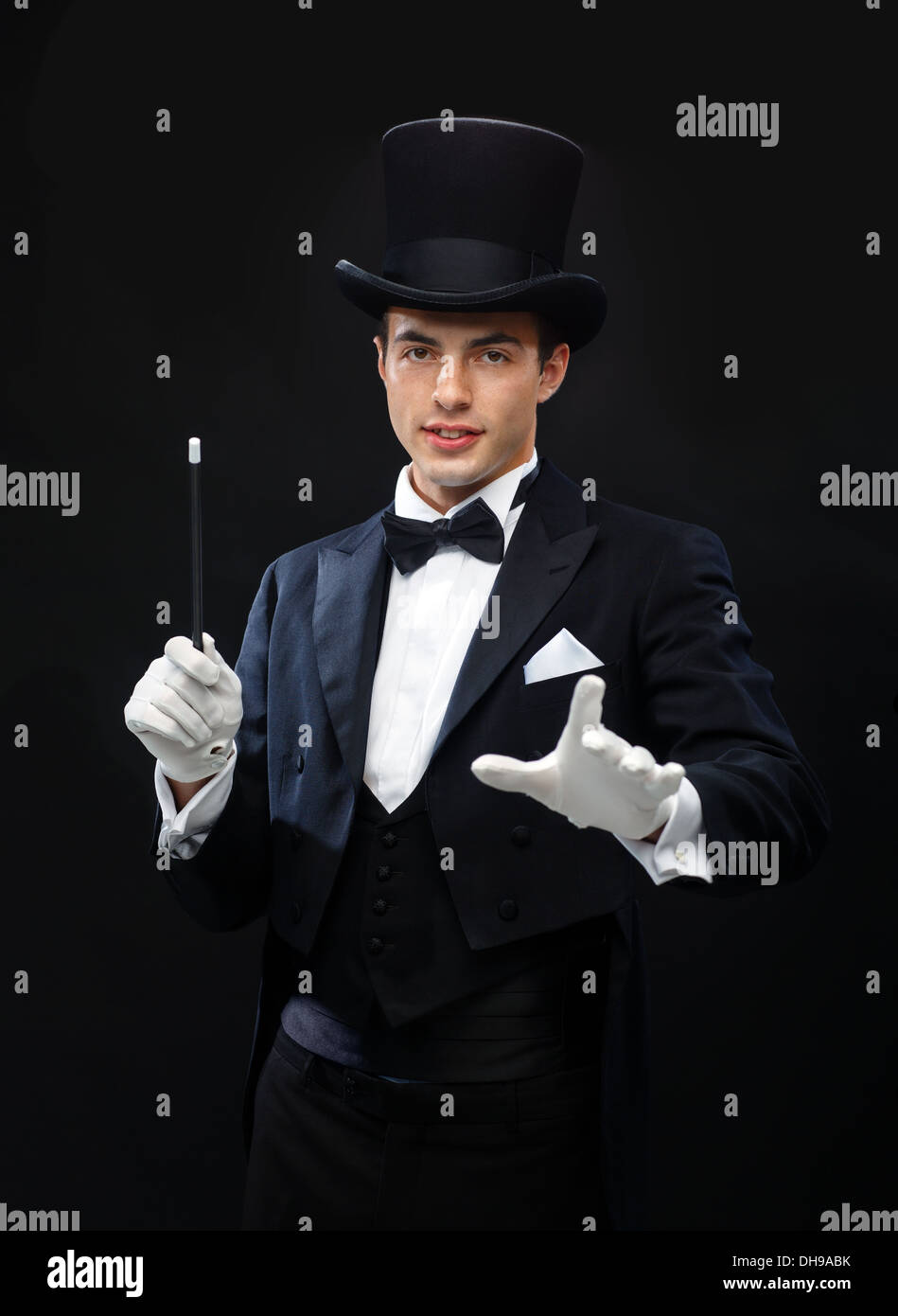 Magicien dans top hat avec Magic wand montrant trick Banque D'Images
