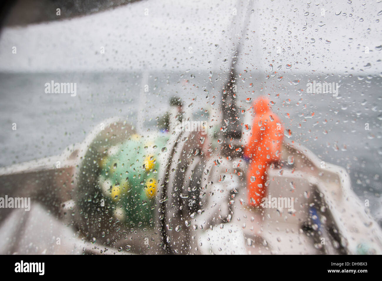 Le capitaine et son matelot, vue à travers une fenêtre humide d'un Bowpicker Bateau de pêche au filet maillant dans le gros temps, la pêche au saumon Banque D'Images