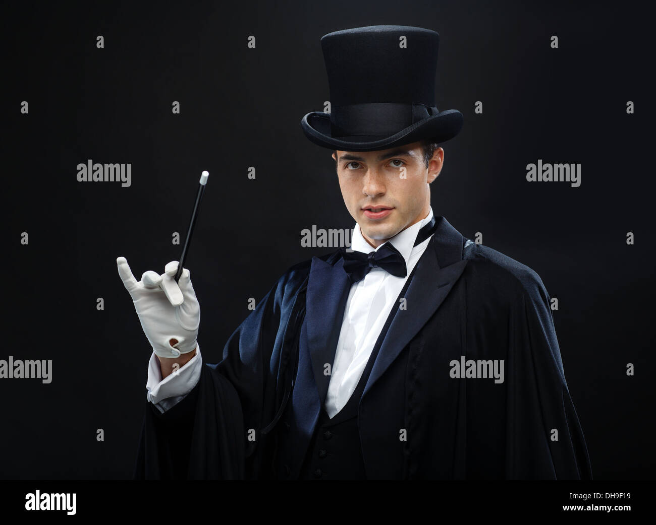 Magicien dans top hat avec Magic wand montrant trick Banque D'Images