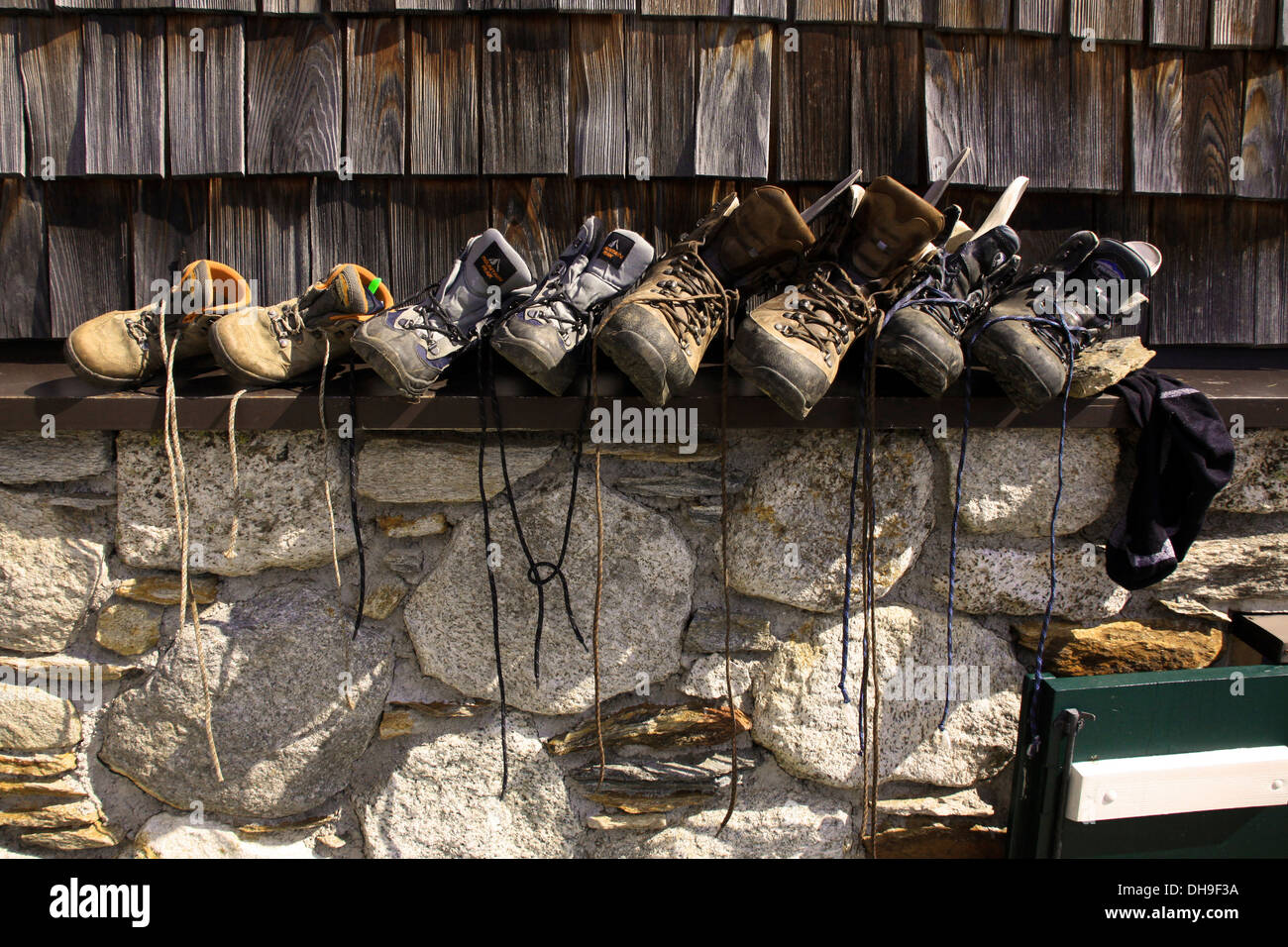 Ligne de chaussures de montagne chaussures de marche et de randonneurs et alpinistes séchant au soleil contre le refuge alpin dans les Alpes Banque D'Images