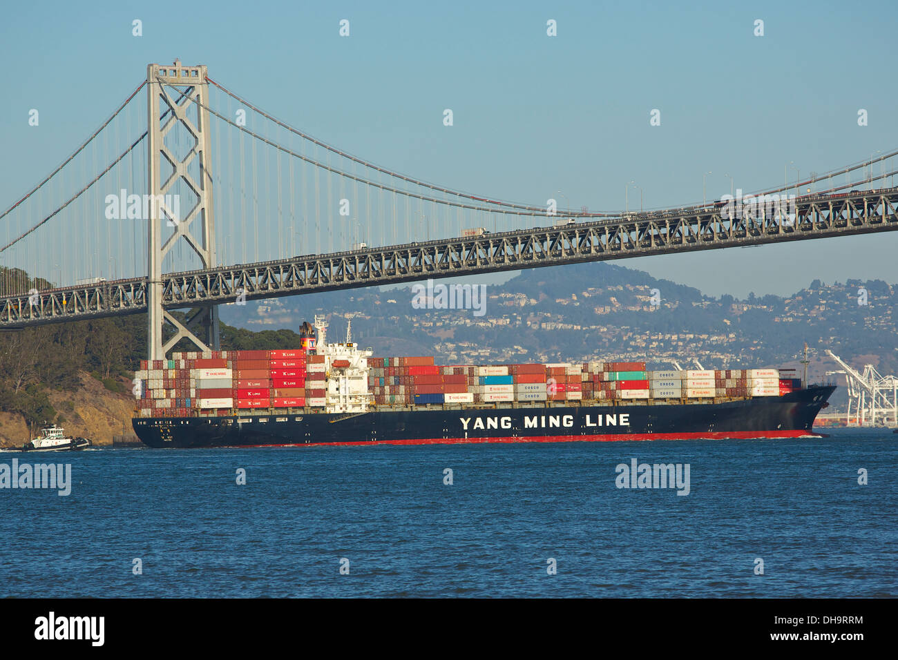 Une ligne Yang Ming-conteneur passe sous le San Francisco-Oakland Bay Bridge, San Francisco, Californie, USA. Banque D'Images