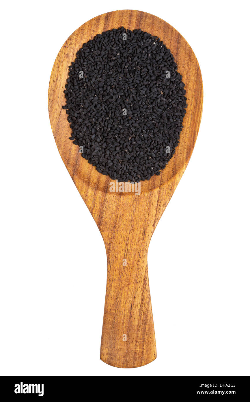 Les graines de cumin noir ou kalonji (Nigella Sativa) dans la cuillère en bois sur fond blanc Banque D'Images