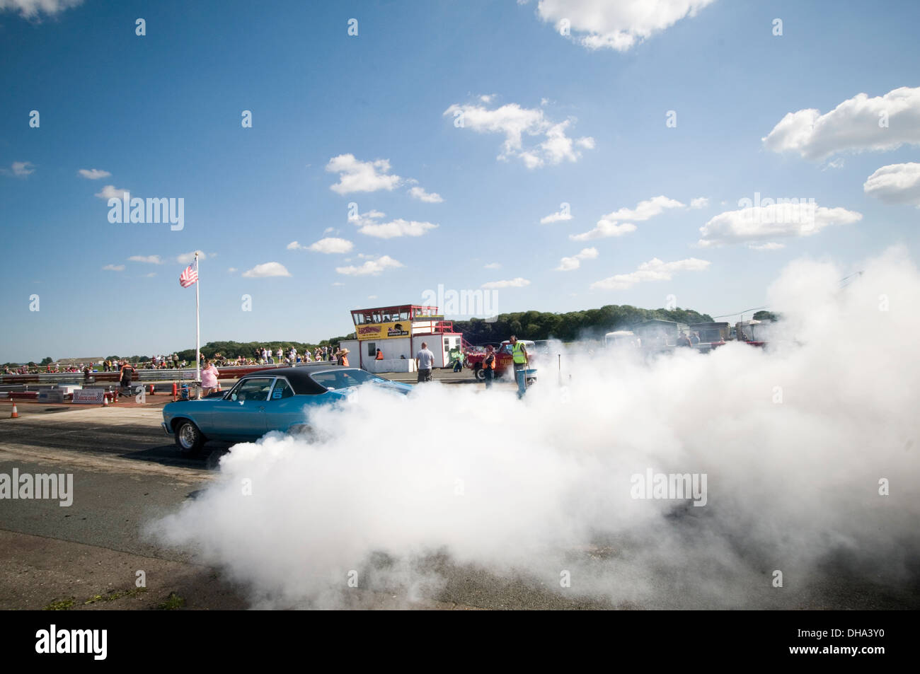 Location de voitures de muscle faisant un burnout à un Dragster faisant tourner les roues pneus hors fumée smokey nappes nappe en caoutchouc chauffage dr Banque D'Images