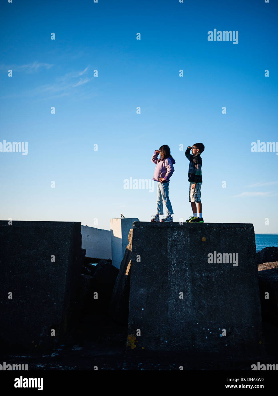 Garçon et fille se tenir sur mur du port et regardez vers la mer. Banque D'Images