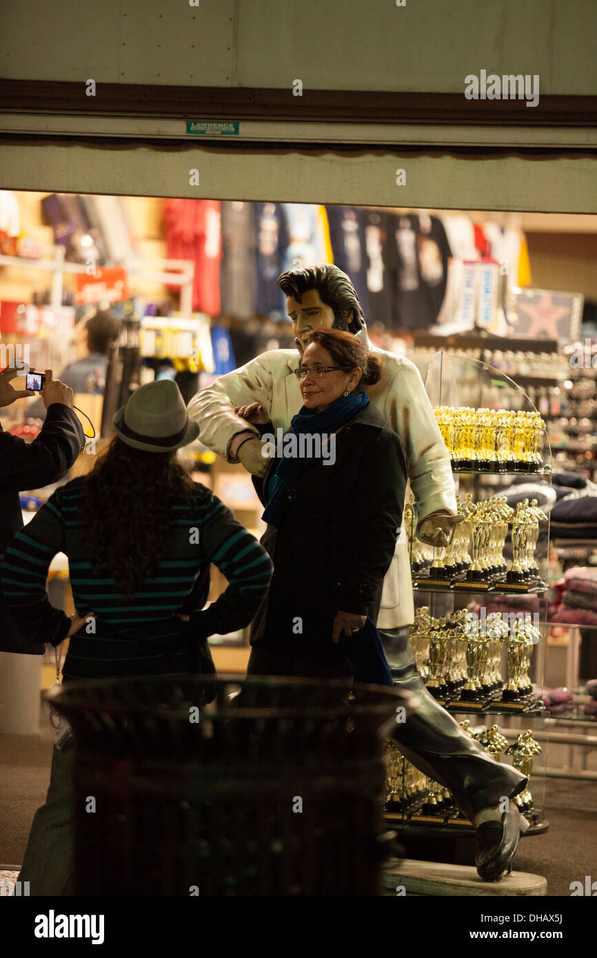 Les touristes posent avec une statue d'Elvis dans un magasin de souvenirs sur Hollywood Boulevard à Hollywood en Californie Banque D'Images