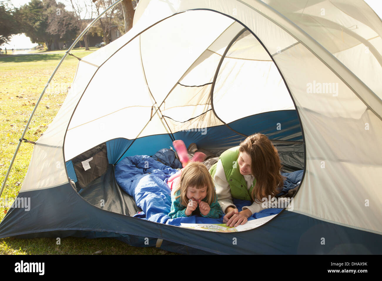 Une mère et fille s'est retrouvée dans une tente de lire un livre ; l'anse du crabe, Alemada, Californie, États-Unis d'Amérique Banque D'Images