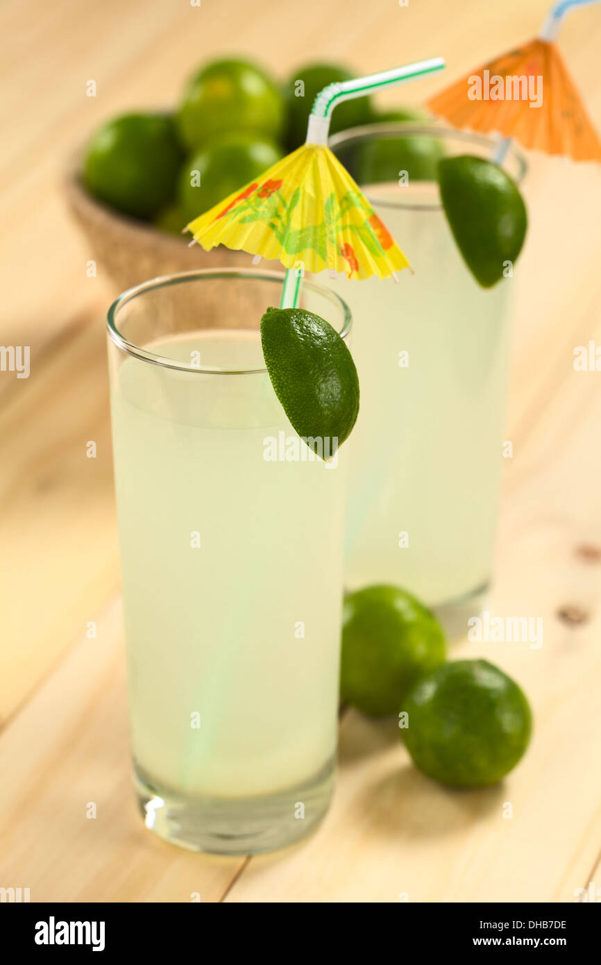 Limonade rafraîchissante fraîchement préparés hors de limes en verre grand garnie avec lime et parasol en papier Banque D'Images