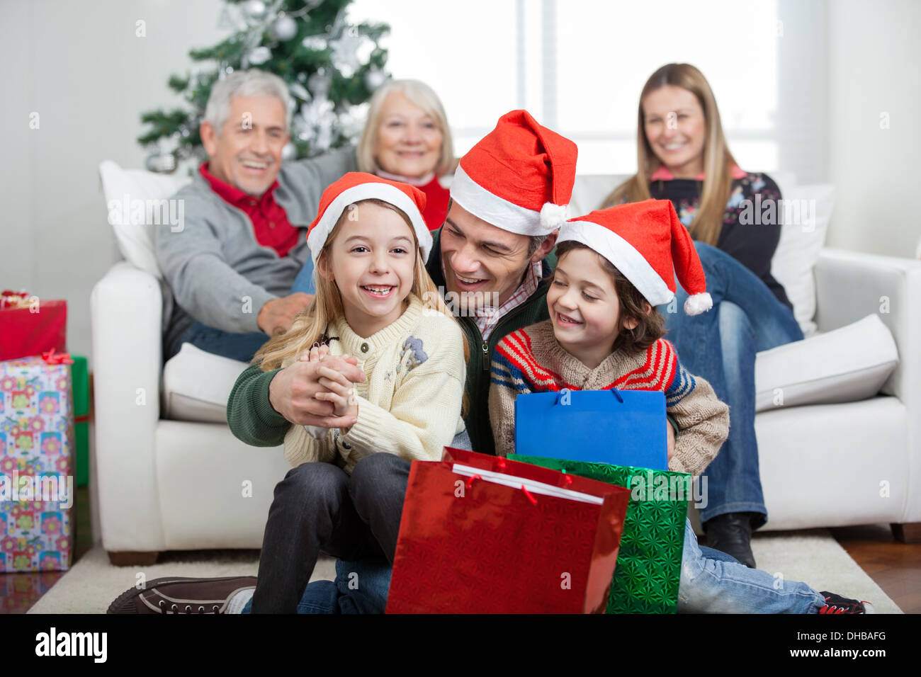 Les enfants et les Père Noël avec cadeaux pendant Banque D'Images