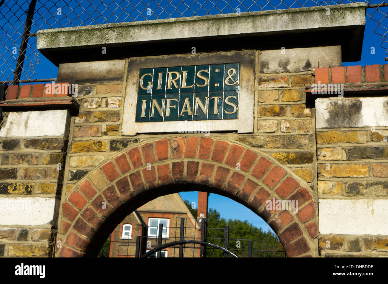 Les filles et les bébés dans des carreaux de céramique au-dessus de l'entrée d'une école primaire dans le sud de Londres. Banque D'Images
